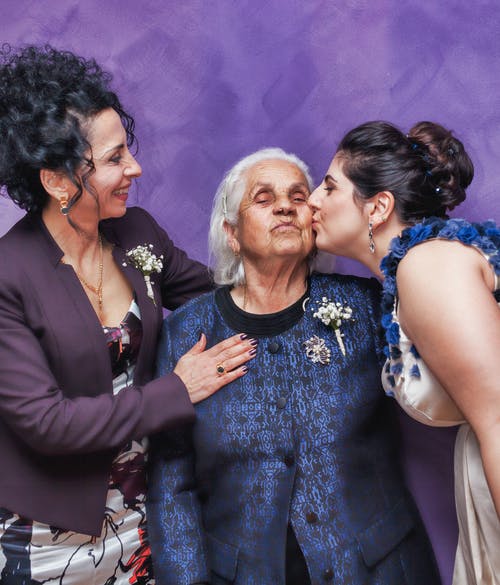 unequal inheritances, image of woman kissing senior woman while another woman shows affection as well